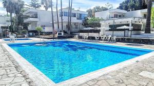 une grande piscine bleue devant un immeuble dans l'établissement Bouganville en Eureka, à Costa del Silencio