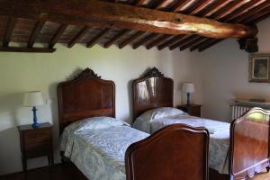 a bedroom with two beds and a wooden ceiling at Torre Di Sant'Ansano in Corsano