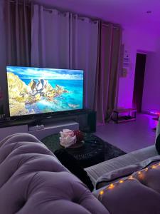 a living room with a large tv and purple lighting at Paris Giverny familles & professionnels in Freneuse