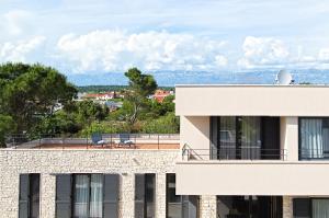 ein Gebäude mit einem Balkon mit zwei Stühlen auf dem Dach in der Unterkunft Villa Pinna in Zaton