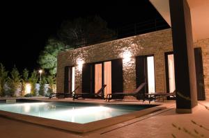 ein Schwimmbad in der Nacht mit Stühlen um ihn herum in der Unterkunft Villa Pinna in Zaton