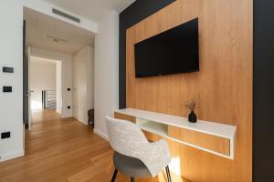 ein Wohnzimmer mit einem Schreibtisch und einem TV an der Wand in der Unterkunft Villa Pinna in Zaton