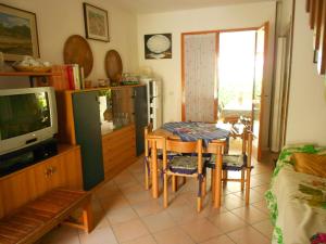 a living room with a table and a tv at Villa Caprera in Rosolina Mare
