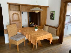 einen Esstisch und Stühle mit einem orangenen Tischtuch in der Unterkunft Ferienwohnungen Wörz, Sigismundstrasse 6 in Oberstdorf
