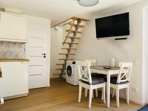 a kitchen and dining room with a table and a tv at Apartamentai ant marių kranto in Neringa