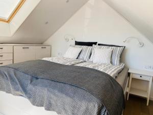 a bedroom with a bed and a desk in a attic at Apartamentai ant marių kranto in Neringa