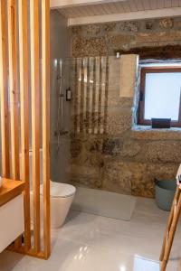 a bathroom with a toilet and a glass shower at Casas da Morgadinha - Arais Turismo Rural in Celorico de Basto