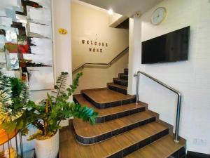 a staircase in a building with a tv on the wall at The Grace Hotel in Muar