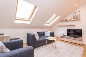 a living room with a blue couch and a tv at Antim Boutique Apartments in Sofia