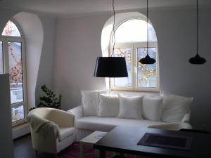 a living room with a white couch and two windows at The Art Quarter in Plovdiv