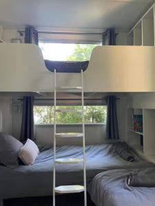 Un dormitorio con dos literas y una ventana. en Chant des Oiseaux ***, en Royan