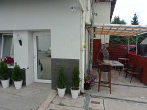 a patio with a table and chairs and potted plants at Apartment hotels parking akaciju1 in Vilnius