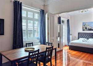 a dining room with a table and chairs and a bed at Elegant apartment in Syntagma square in Athens