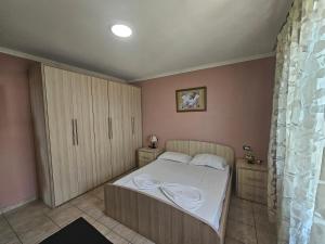 niewielka sypialnia z łóżkiem i szafką w obiekcie Bral Apartments w Durrës