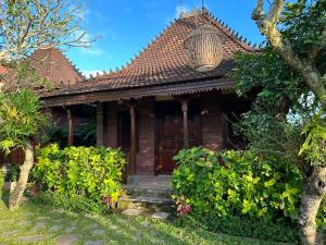 a house with a wooden door and a porch at Munay Villa in Ubud