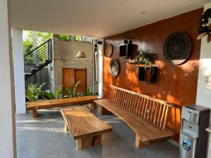 a room with two wooden benches and a fireplace at Munay Villa in Ubud