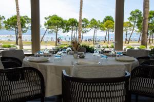 a dining room with a table and chairs and the ocean at Abi's Hotel & SPA Vlore in Vlorë