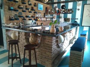 a bar in a kitchen with two stools and a counter at Pousada Ancora in Vera Cruz de Itaparica