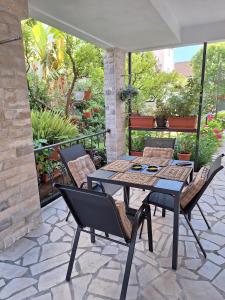 a patio with a table and chairs on a patio at Apartmani Hortenzija in Budva