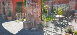 ein schmiedeeisernes Tor mit Pflanzen auf einem Backsteingebäude in der Unterkunft Pension Am Dorfanger in Hohennauen