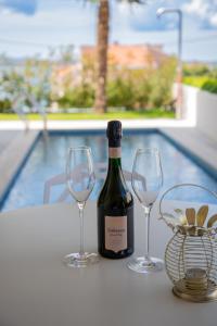 een fles wijn en twee wijnglazen op een tafel bij GALA'Pe in Zadar