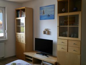 a bedroom with a tv and a dresser at Weidenhof Zinnowitz in Zinnowitz