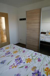 a bedroom with a bed with a floral bedspread at Weidenhof Zinnowitz in Zinnowitz