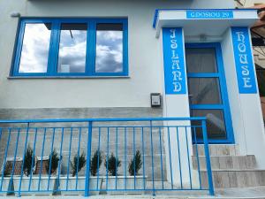 a building with a blue door and a window at Island House Kavala in Kavála