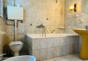 un bagno con vasca, WC e lavandino di Central with Parking 3 Bedroom Apartment a Novi Sad Altre 17 foto