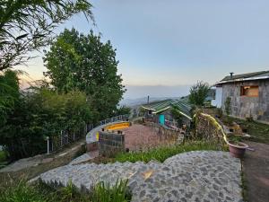 a garden with a fence and a house on a hill at The Vanya, Boutique Stay in Rāmgarh