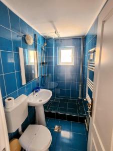 a blue tiled bathroom with a toilet and a sink at Vilele Liliana in Mamaia Sat/Năvodari +118 photos