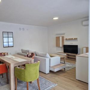 a living room with a couch and a table at Apartman Milos - centar grada free parking in Vranje +7 photos