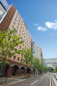 uma rua da cidade com um grande edifício ao lado da estrada em Dukes Hotel Hakata em Fukuoka