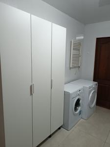 a laundry room with a washing machine and white cabinets at Atpūtas vieta Buki in Ventspils