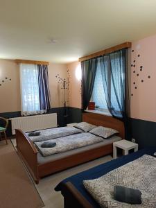 a bedroom with two beds and two windows at Atpūtas vieta Buki in Ventspils