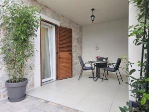 a patio with a table and chairs and plants at Apartments Miamare in Primošten