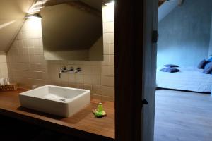 un bagno con un lavandino e un letto in una stanza di 15 inn a Mol