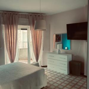 une chambre avec un lit, une commode et une fenêtre dans l'établissement La casa della felicità, à Francavilla al Mare