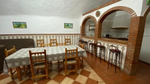 a dining room with a table and chairs and a kitchen at Cuevas Cañada de las Piedras in Graena
