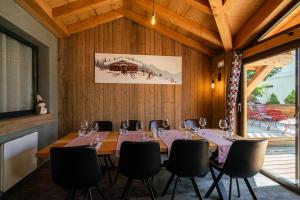 ein Esszimmer mit einem langen Tisch und Stühlen in der Unterkunft Chamois Lodge in Les Deux Alpes