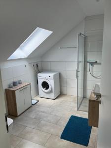 a bathroom with a washing machine and a washer at Auszeit im Grünen in Hopsten