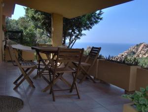 uma mesa e cadeiras numa varanda com vista para o oceano em Villetta Vista Mare em Costa Paradiso
