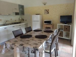 a kitchen with a table with chairs and a refrigerator at Villetta Vista Mare in Costa Paradiso +21 photos