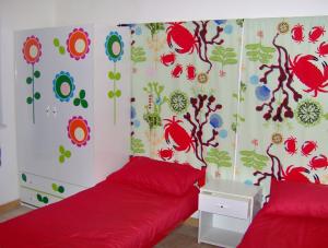 a bedroom with two beds and a red bedspread at Villetta Vista Mare in Costa Paradiso