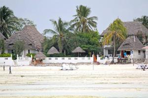 ジャンビアニにあるHayam Private Pool Villa 1min beach servicedのいくつかの家の前の浜辺に横たわる牛