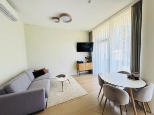 een woonkamer met een bank en een tafel bij Moon apartment in Druskininkai