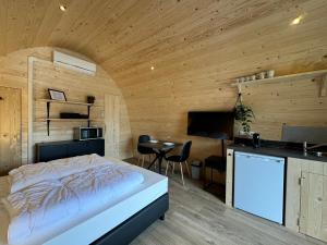 a bedroom with a bed and a kitchen and a table at Woodlodge de luxe 2 persoons in Oorsbeek