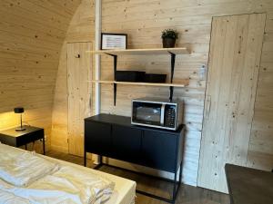 a room with a bed and a television on a desk at Woodlodge de luxe 2 persoons in Oorsbeek +14 photos