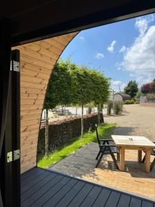 a patio with a table and a bench on a deck at Woodlodge de luxe 2 persoons in Oorsbeek