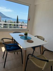 a white table and chairs in a room with a window at Apartments Mitende in Budva